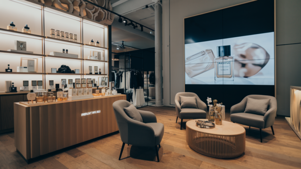 A luxurious experiential retail space featuring an interactive perfume testing station and a digital fashion try-on mirror, enhancing customer engagement.